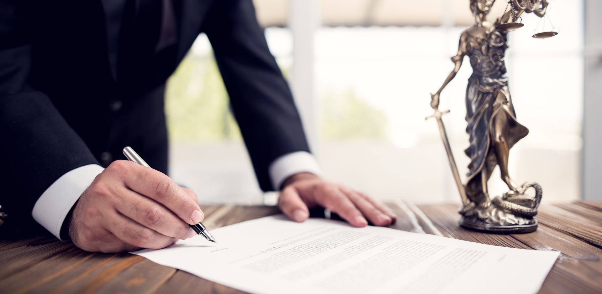 Man in navy suit signing legal documents